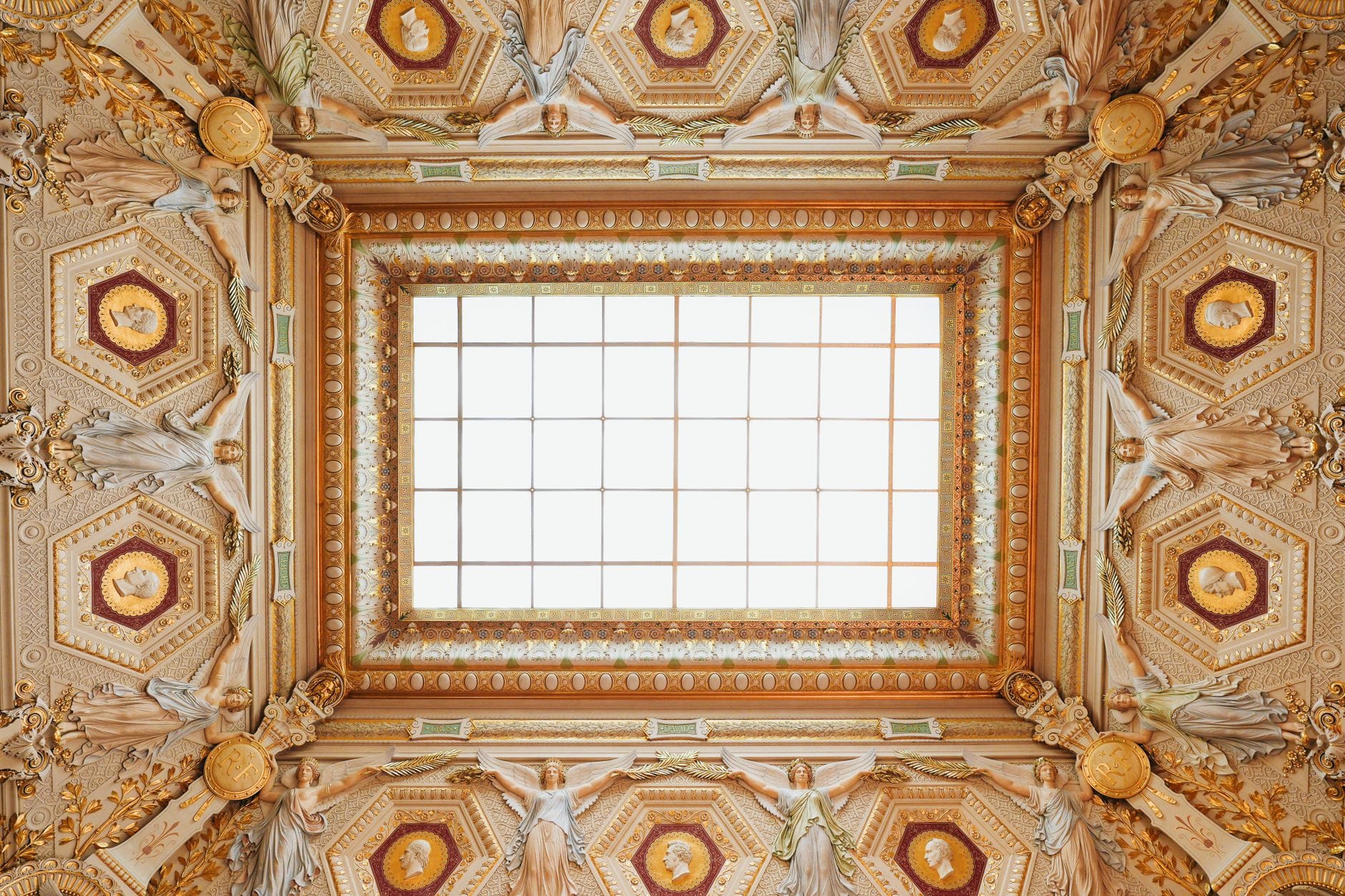 A beautifully designed ceiling with intricate details and a central skylight.